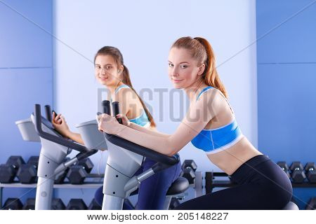 Group of people at the gym exercising on cross trainers. People at the gym