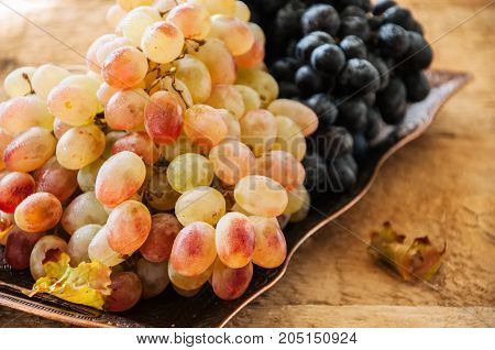 Two Type Of Fresh Ripe Grapes Blue And Green On A Vintage Old Tray. Close Up.