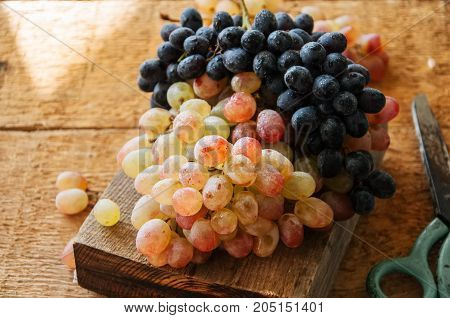 Two Type Of Fresh Ripe Grapes Blue And Green. On A Wooden Background. Close Up.