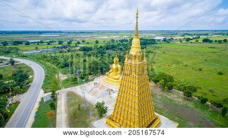 Aerial Shot : The big golden Buddha statue in Ayutthaya, Thailand. sky and rice field background.