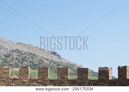 Sudak Crimea Russia June 29 2017: Old wall with battlement in Sudak fortress Crimea. Mountain on the background.