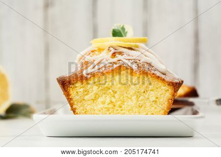 Lemon loaf cake with white glaze and lemon slices. Selective focus. Space for text