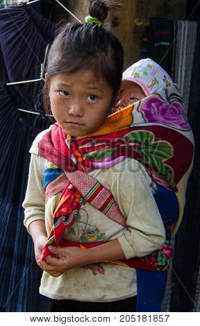 Vietnamese Child Carries Little Brother On Her Back