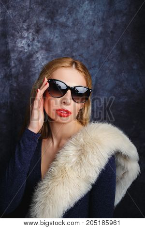 Stylish blonde in arctic fox and sun glasses.