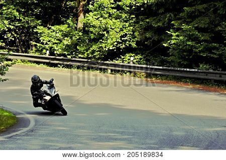picture of biker on motorcycle riding through curve