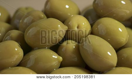 Large shiny green olives macro for background