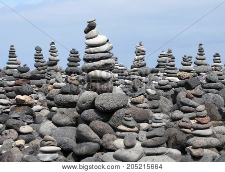 rock art piles and towers of grey stones and pebbles on a beach