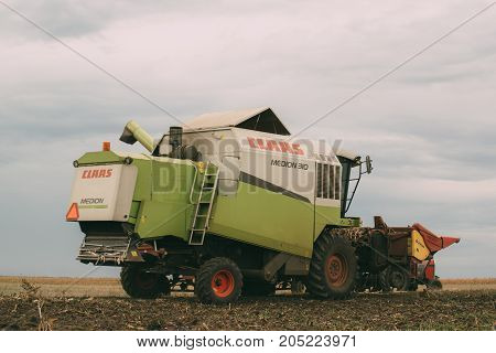 ZRENJANIN SERBIA - SEPTEMBER 19 2017: Combine harvester auger unloading harvested corn into tractor trailer. Lower maize crop yield expected this year in Vojvodina region due to drought during summer.