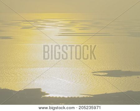 Setting Sun reflects from vast ocean surface creating beautiful effect