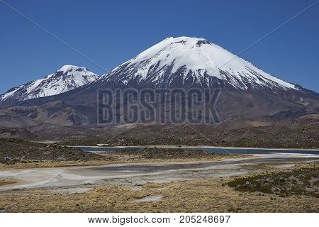 Volcanoes Parinacota and Pomerape in Lauca National Park high on the Altiplano of northern Chile. In the foreground lakes known as Lagunas de Cotacani