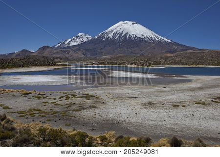 Volcanoes Parinacota and Pomerape in Lauca National Park high on the Altiplano of northern Chile. In the foreground lakes known as Lagunas de Cotacani