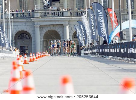 STOCKHOLM - AUG 26 2017: Distant group of fighting male triathlete cyclists royal castle in the background in the Men's ITU World Triathlon series event August 26 2017 in Stockholm Sweden