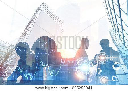 Close up of business people silhouettes communicating and standing against a cityscape. HUD and graphs. Toned image double exposure