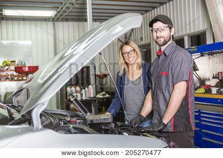 An auto mechanic and female customer in garage