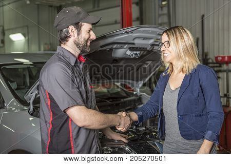 An auto mechanic and female customer in garage
