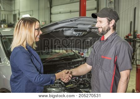 An auto mechanic and female customer in garage