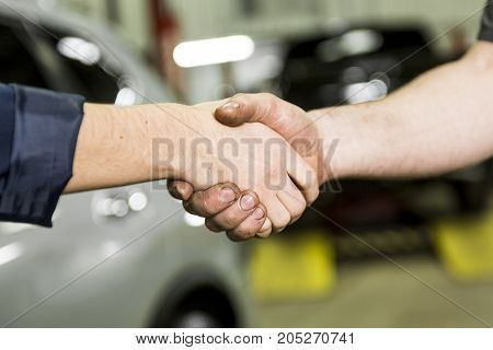 An auto mechanic and female customer in garage