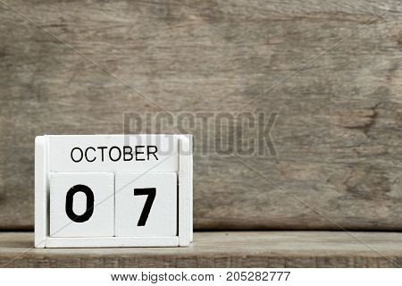 White block calendar present date 7 and month October on wood background