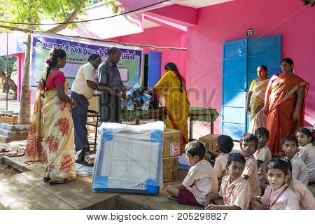 PONDICHERY PUDUCHERY INDIA - SEPTEMBER 04 2017. Outdoor meeting of the children of the school with uniforms sitting on the floor waiting for sport equipments as a gift from an association.