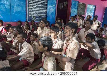 PONDICHERY PUDUCHERY INDIA - SEPTEMBER 04 2017. Outdoor meeting of the children of the school with uniforms sitting on the floor waiting for sport equipments as a gift from an association.