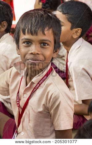 PONDICHERY PUDUCHERY INDIA - SEPTEMBER 04 2017. Outdoor meeting of the children of the school with uniforms sitting on the floor waiting for sport equipments as a gift from an association.