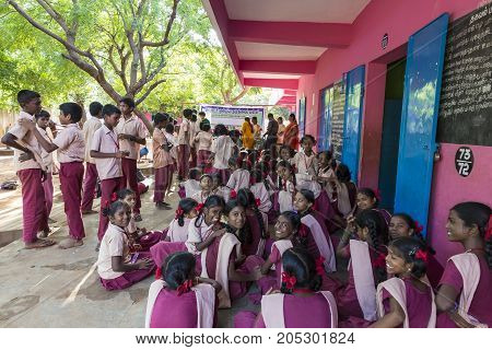 PONDICHERY PUDUCHERY INDIA - SEPTEMBER 04 2017. Outdoor meeting of the children of the school with uniforms sitting on the floor waiting for sport equipments as a gift from an association.