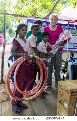 PONDICHERY PUDUCHERY INDIA - SEPTEMBER 04 2017. Outdoor meeting of the children of the school with uniforms sitting on the floor waiting for sport equipments as a gift from an association.