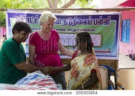 PONDICHERY PUDUCHERY INDIA - SEPTEMBER 04 2017. Outdoor meeting of the children of the school with uniforms sitting on the floor waiting for sport equipments as a gift from an association.