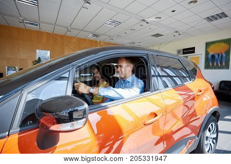 The beautiful couple chose a new car for themselves. The concept of buying a new car.