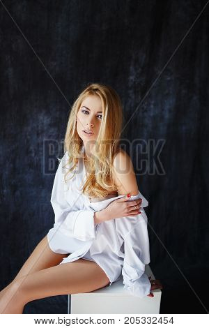Sexy blonde slim fit woman with great body in lingerie underwear and in men's white shirt in sexy, sensual, hot pose