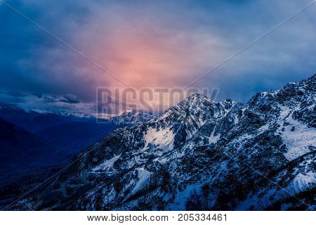 View to the snowy mountains with a dramatic clouded sky in Sochi, Russia