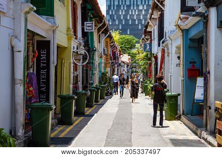 SINGAPORE - SEPTEMBER 7 2017: Shoppers walking along famous Haji Lane in Kampong Glam's muslim enclave where fashion boutiques eclectic collection of trendy stores and Middle Eastern cafes abound in old colonial shop houses.