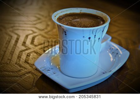 coffee grounds. table background. a cup on the table. coffee foam. brown table and white tableware