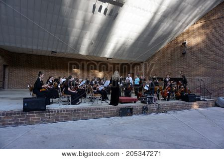 JOLIET, ILLINOIS / UNITED STATES - JUNE 1, 2017: The Metropolitan Youth Symphony Orchestra (MYSO) prepares to perform a free public concert at the outdoor theater in the Billie Limacher Bicentennial Park.