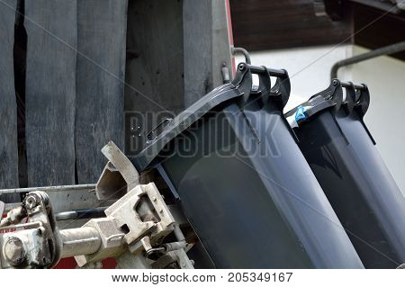 accumulated household refuse is collected - close-up of rubbish bin emptying