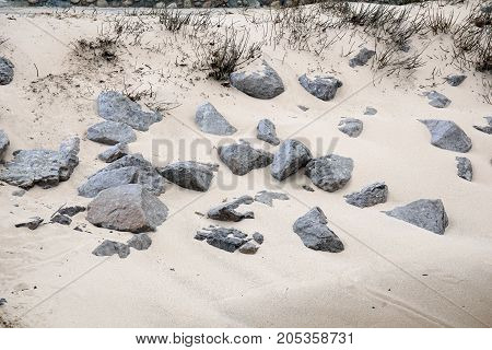 Rocks lie in the sand at the beach in Wequetonsing, Michigan, during March.