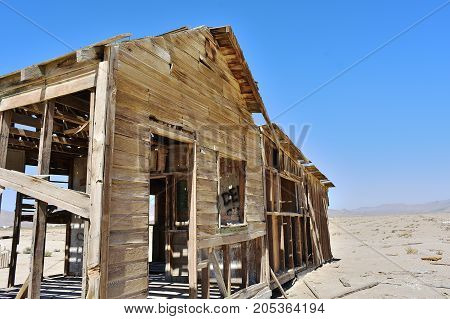 Ruined house in the desert. Decaying wood in the sun.