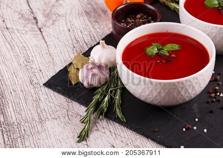 Soup in a bowl with dill, sour cream and black bread on wooden background. National dish of Ukrainian cuisine.