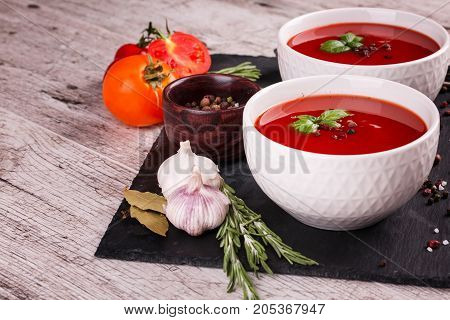 Soup in a bowl with dill, sour cream and black bread on wooden background. National dish of Ukrainian cuisine.