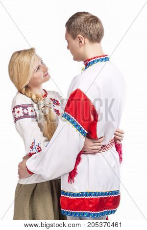 Fashion Ideas. Portrait of Loving Embraced Caucasian Couple in National Belarussian and Russian Decorated Costumes. Against White Background. Vertical Shot