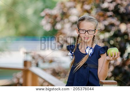 Adorable little school girl with notes and pencils outdoor.