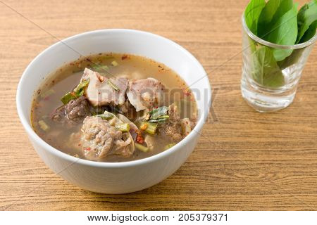 Thai Cuisine and Food A Bowl of Thai Clear Spicy Hot and Sour Soup of Beef Entrails Served with Sweet Basils.