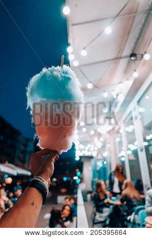 hand holding cotton candy on the night street