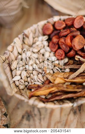 food, healthy lifestyle, gourmet kitchen concet. close up of wickerwork picnic hamper with different delicious snakes such as pistachio nuts, dried apricots and bean sprouts