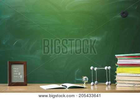 Teacher or student desk table. Education background. Education concept. Photo frame book copybook with pen molecule model and globe on the table.