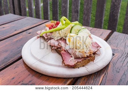 Traditional bread with lots of cold cuts on wooden table on south Styrian vine route in Austria