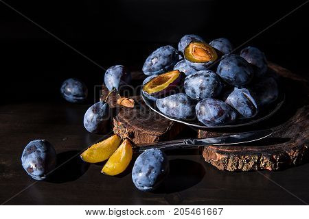 Fresh blue plums on wood slised with drops of water