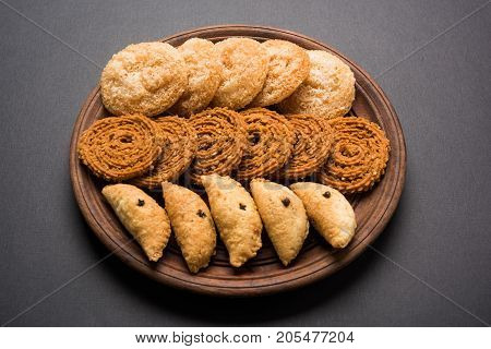 stock photo of Indian festival or diwali food called chakli, anarsa and karanji or Gujiya, selective focus