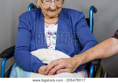 Holding a Senior Citizens Hand
Male hand holding the hands of a senior citizen in a wheelchair.