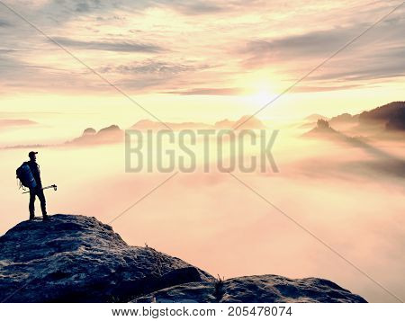 Man Silhouette With Poles In Hand. Sunny Spring Daybreak And Tourist Guide Stay On Sharp Cliff Of Mo